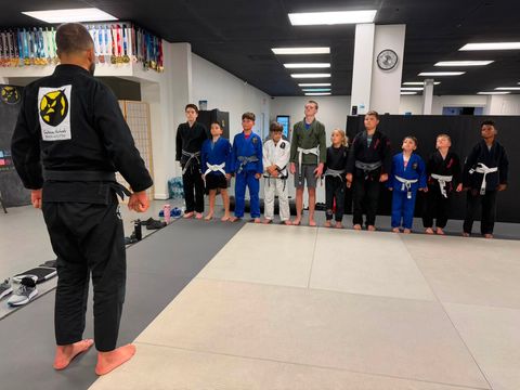 Kids & Teen BJJ students in gis lined up for class with their instructor in Venice FL