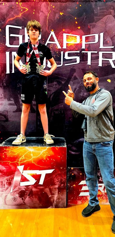 Youth BJJ student winning first place with his coach